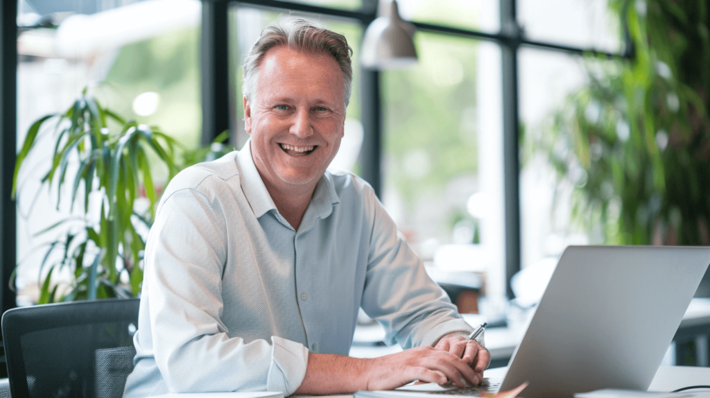 A smiling middle-aged man working on his laptop