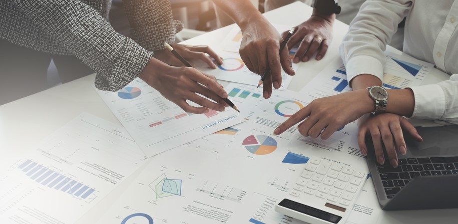 a group of businesspeople in a team meeting pointing to a graph