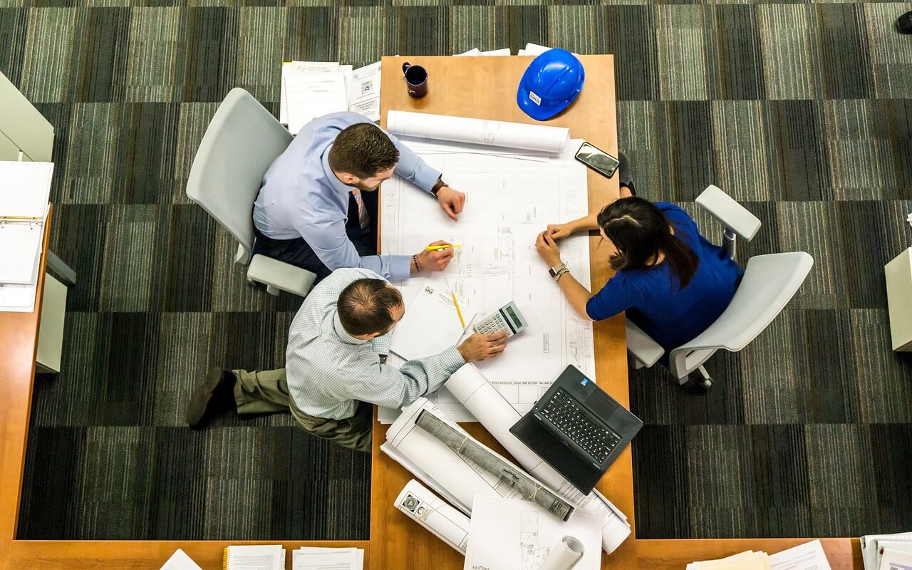 A group of people making calculations at a business meeting in an office