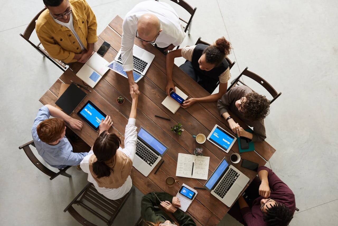 A professional team working by the same table on laptops and mobile devices