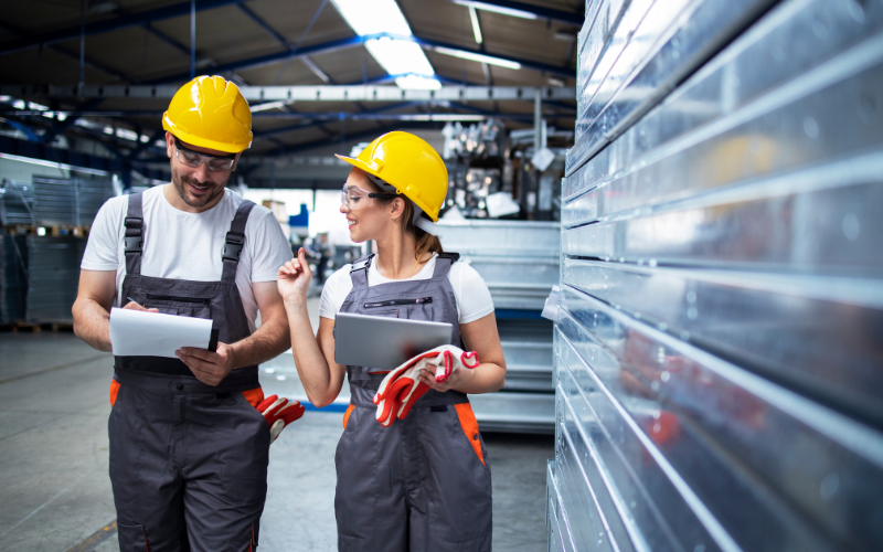Two employees discussing manufacturing process improvement